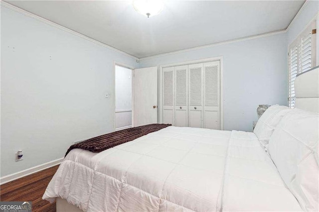 bedroom with dark wood-type flooring, a closet, and crown molding