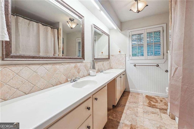 bathroom with vanity, toilet, and decorative backsplash