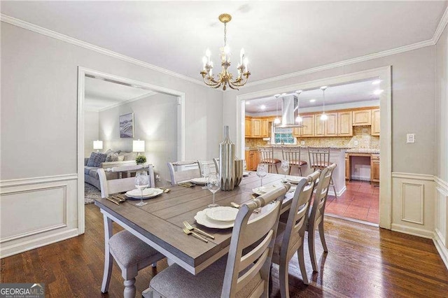 dining area with dark hardwood / wood-style floors, crown molding, and an inviting chandelier