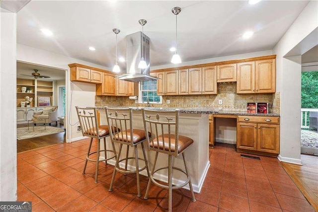 kitchen with a center island, decorative light fixtures, island range hood, and dark hardwood / wood-style flooring