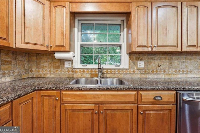 kitchen featuring tasteful backsplash, sink, dark stone counters, and stainless steel dishwasher