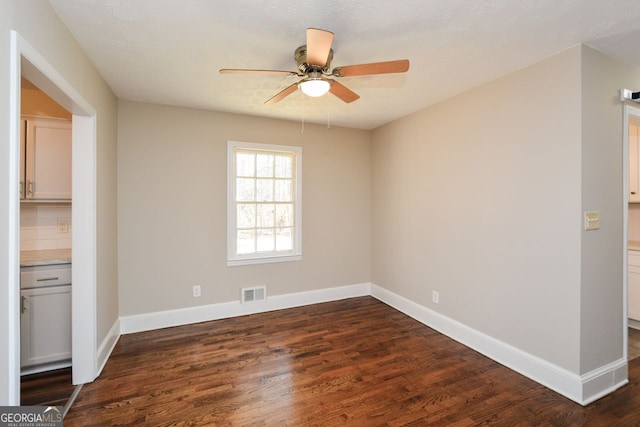 unfurnished room featuring ceiling fan and dark hardwood / wood-style flooring