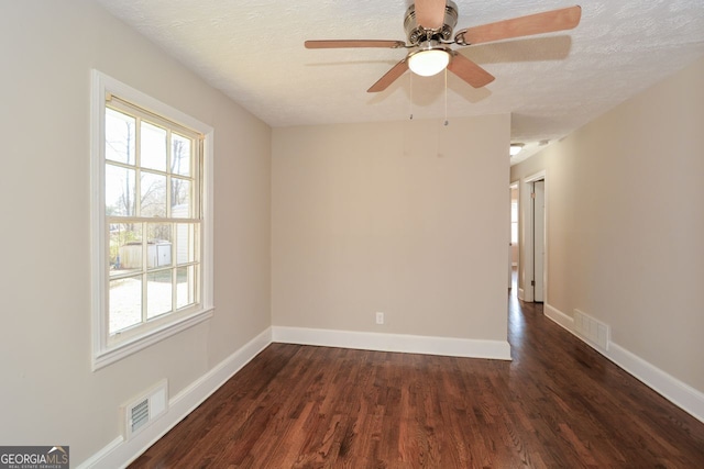 unfurnished room with a textured ceiling and dark wood-type flooring