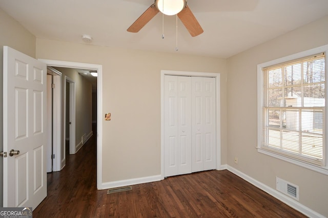 unfurnished bedroom featuring a closet, dark hardwood / wood-style flooring, and ceiling fan