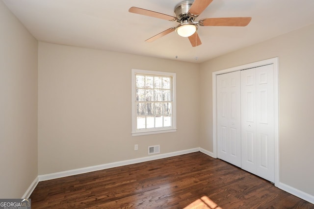 unfurnished bedroom featuring ceiling fan, a closet, and dark hardwood / wood-style floors