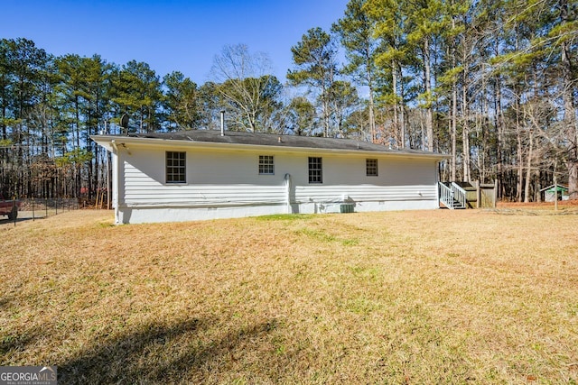 rear view of house featuring a lawn and central AC unit