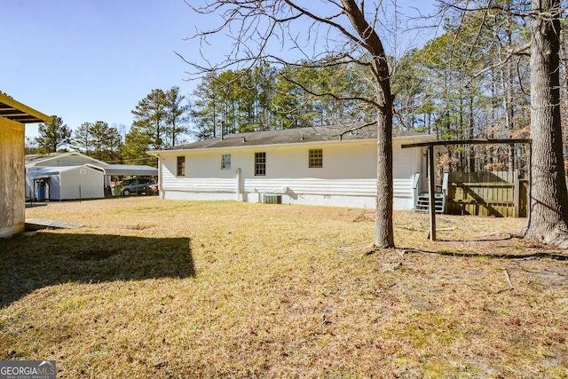 back of house with cooling unit, a yard, and a carport