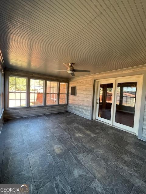 unfurnished sunroom with ceiling fan and wooden ceiling