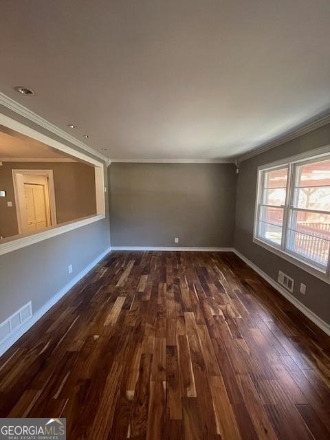 empty room featuring crown molding and dark wood-type flooring