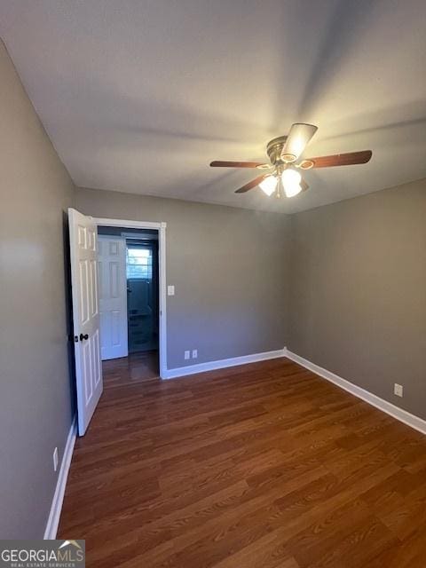 unfurnished room with ceiling fan and dark hardwood / wood-style floors