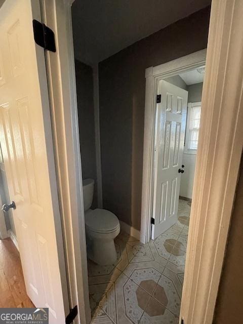 bathroom with hardwood / wood-style flooring and toilet