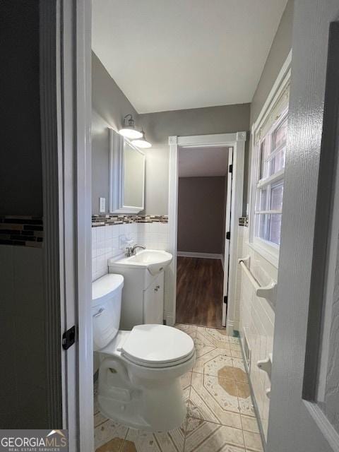 bathroom featuring tile patterned floors, vanity, tile walls, and toilet