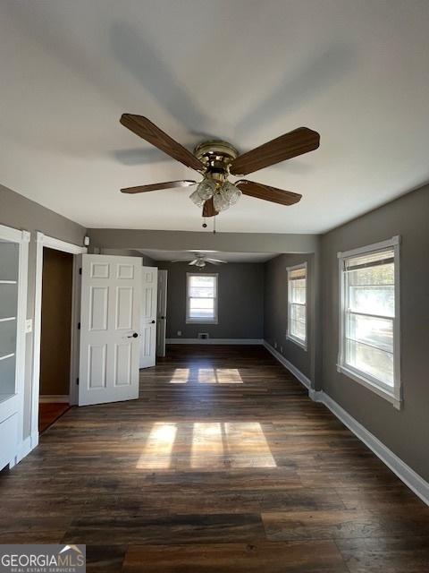 unfurnished bedroom with ceiling fan and dark wood-type flooring