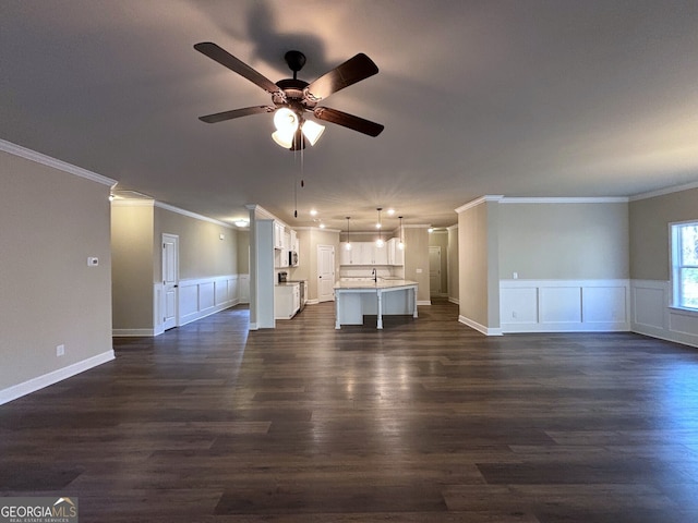 unfurnished living room with ceiling fan, dark hardwood / wood-style floors, and ornamental molding