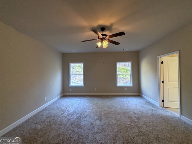 carpeted spare room with a wealth of natural light and ceiling fan