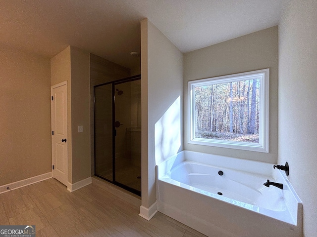 bathroom with hardwood / wood-style floors and independent shower and bath