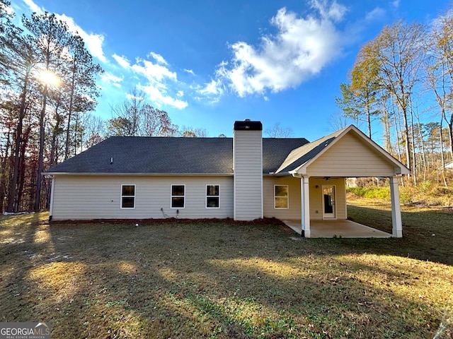 back of house featuring ceiling fan, a patio area, and a lawn