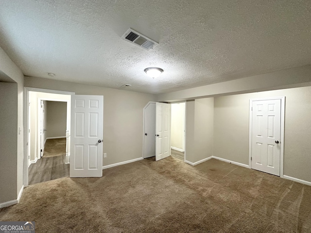 interior space with a textured ceiling and carpet floors