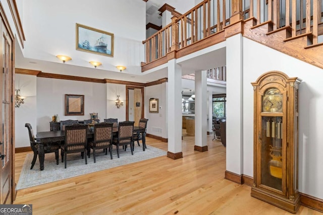 dining area featuring light hardwood / wood-style flooring and a high ceiling