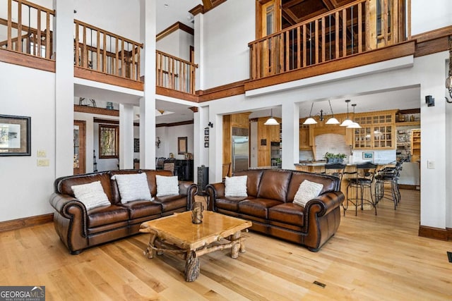 living room with hardwood / wood-style floors and a towering ceiling