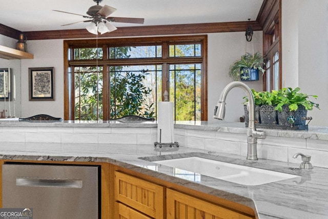 kitchen with ceiling fan, light stone counters, and sink