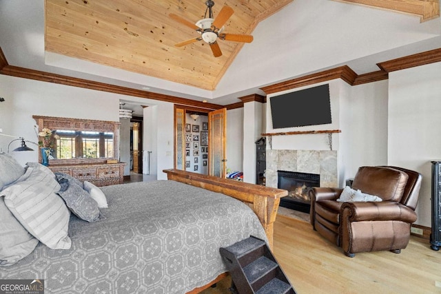 bedroom with wooden ceiling, high vaulted ceiling, light hardwood / wood-style flooring, ceiling fan, and a tiled fireplace