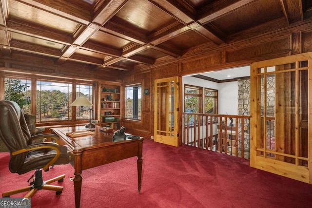 carpeted home office featuring wooden ceiling, coffered ceiling, crown molding, wooden walls, and beam ceiling