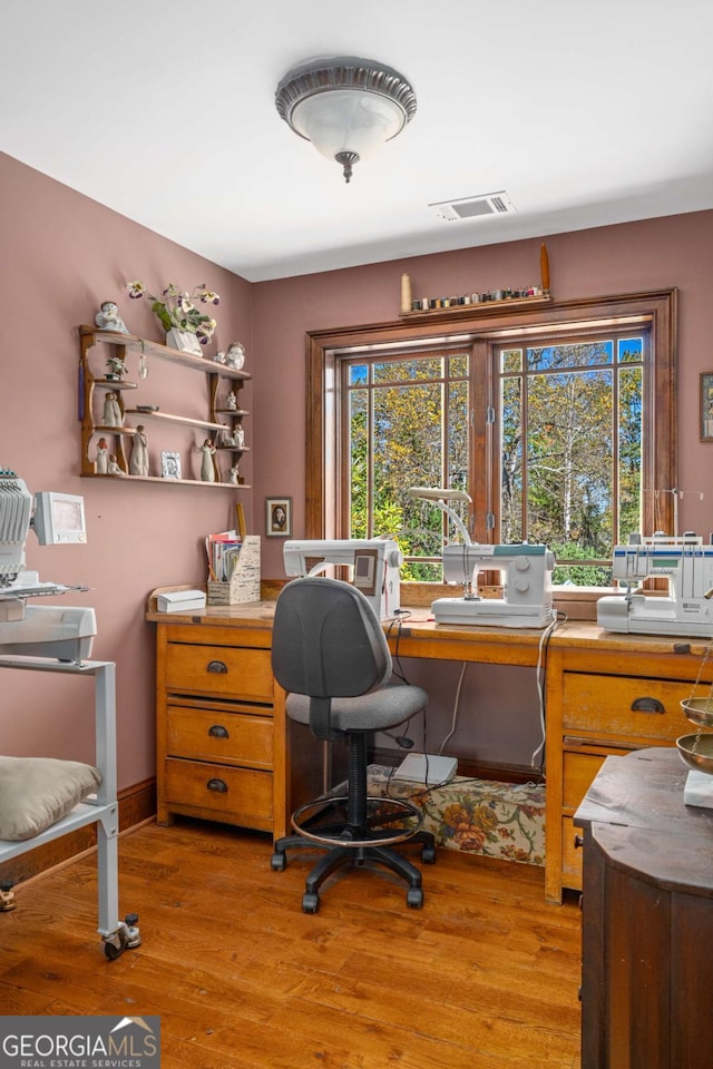 home office with light hardwood / wood-style floors