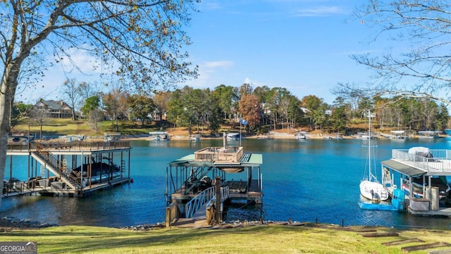 view of dock with a lawn and a water view