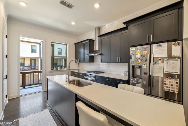 kitchen featuring sink, wall chimney exhaust hood, stainless steel appliances, dark hardwood / wood-style floors, and crown molding