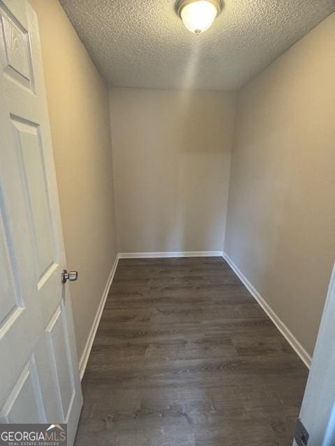 unfurnished room with dark hardwood / wood-style flooring and a textured ceiling