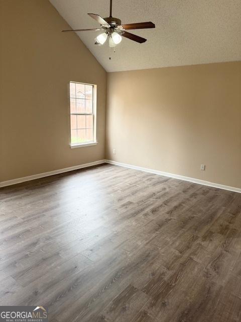 empty room featuring hardwood / wood-style flooring, ceiling fan, a textured ceiling, and high vaulted ceiling