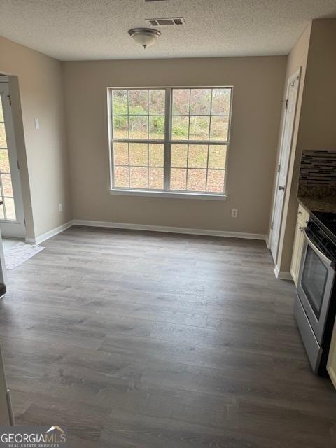 unfurnished living room featuring a textured ceiling and hardwood / wood-style flooring