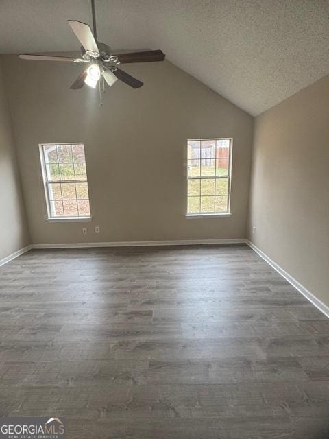 unfurnished room featuring a textured ceiling, ceiling fan, high vaulted ceiling, and dark hardwood / wood-style floors