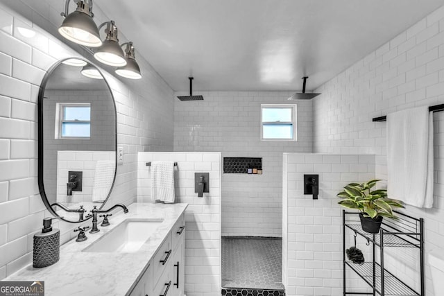 bathroom featuring vanity, a healthy amount of sunlight, and walk in shower