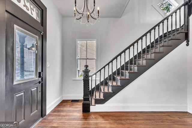 foyer featuring a chandelier and dark wood-type flooring