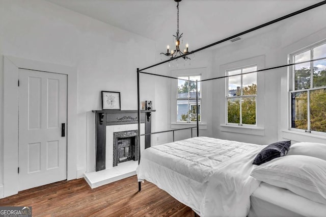 bedroom featuring a chandelier and wood-type flooring