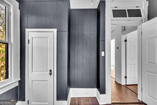 interior space featuring hardwood / wood-style floors and wooden walls