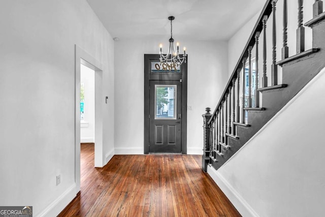 foyer entrance featuring plenty of natural light, dark hardwood / wood-style flooring, and a chandelier