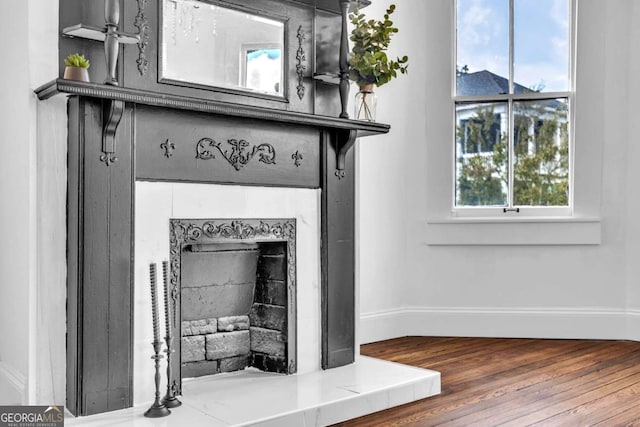 room details with a tile fireplace and wood-type flooring