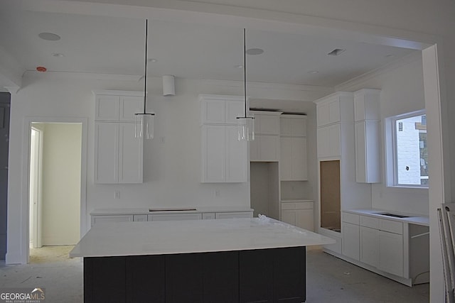 kitchen with white cabinets, a center island, decorative light fixtures, and ornamental molding