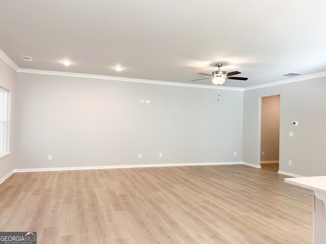 unfurnished room featuring ceiling fan, ornamental molding, and light wood-type flooring