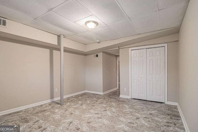 unfurnished bedroom featuring a closet and a drop ceiling