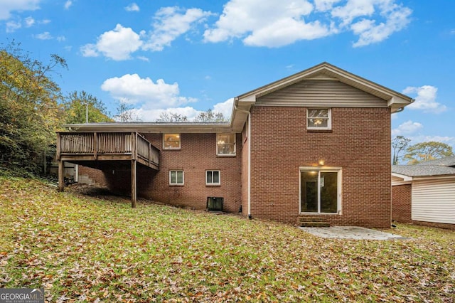 rear view of house with a yard, cooling unit, and a deck