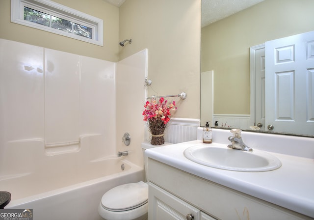 full bathroom with vanity,  shower combination, toilet, and a textured ceiling