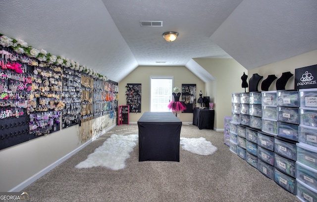 home office with a textured ceiling, light colored carpet, and vaulted ceiling