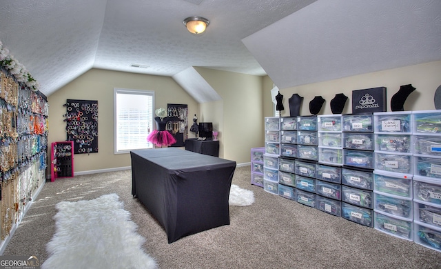 office area with a textured ceiling, carpet, and lofted ceiling