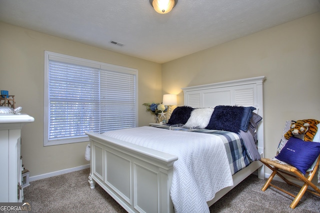 bedroom featuring a textured ceiling and carpet floors