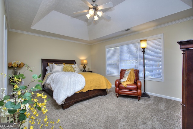 carpeted bedroom with ceiling fan, ornamental molding, and a tray ceiling