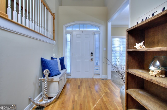 foyer with crown molding and hardwood / wood-style floors